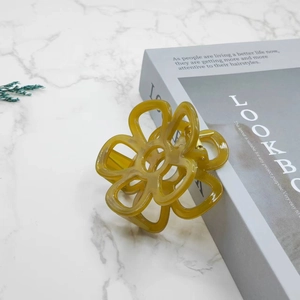 Elegant amber flower hair claw clip with a glossy translucent finish on marble background