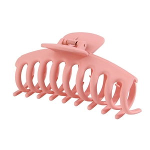 Dettaglio di un grande mollettone rosa opaco per capelli folti per lo styling e il fissaggio