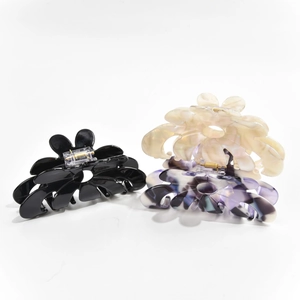 Detailed close-up showing black, beige, and purple marble flower hair claw clips in acetate