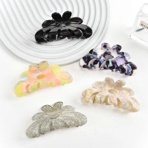 Floral acetate hair claws in black, purple, yellow, cream, and silver glitter finishes
