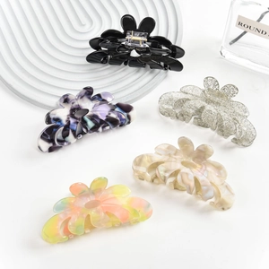 Detailed view of large floral acetate hair claws in five elegant marble and glitter finishes