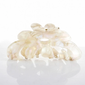 Detail of cream floral acetate hair claw clip with pearlescent finish and metal spring