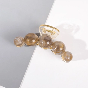 Détail d'une grande pince à cheveux à perles ambrées avec ressort métallique solide