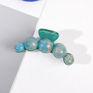 Détail d'une grande pince à cheveux avec sphères marbrées ambre bleu et or et ressort