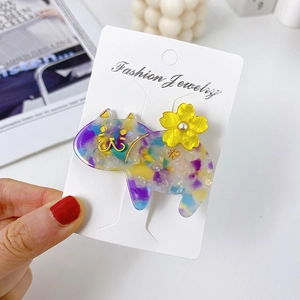 Detail of floral patterned cat-shaped hair clip with small yellow 3D flower and pearl