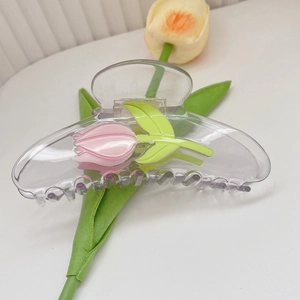 Détail d'une pince à cheveux tulipe transparente avec fleurs roses et feuilles