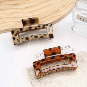 Detail of square leopard print hair claws with glossy tortoiseshell resin texture