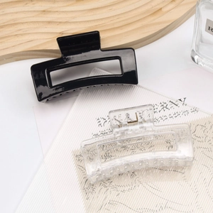 Close-up of square hollow hair claws in glossy black and frosted clear resin material