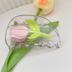 Détail de la pince à cheveux transparente avec tulipe rose 3D et feuilles vertes en acétate