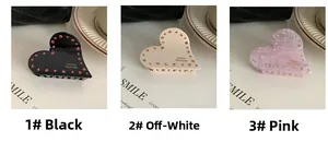Dettaglio di pinze per capelli a cuore fatte a mano con strass in nero, beige e rosa