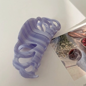 Detail of a large purple marble acetate hair claw clip with elegant hollow structure
