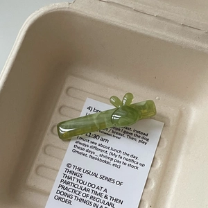Détail d'une pince à cheveux lapin en acétate vert translucide avec texture marbrée