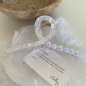 Détail de la pince à cheveux perle sirène avec fini nacré et ressort doré