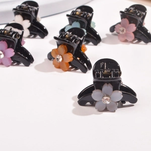 Close-up of mini flower hair clips with colorful rhinestone petals on white background