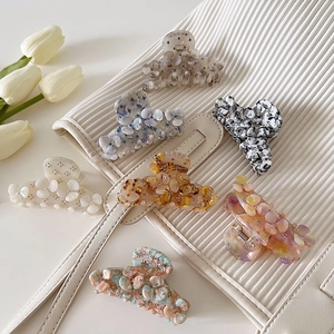 Blumen-Haarklammern aus Acetat mit Strass in 7 Farben auf eleganter weißer Tasche