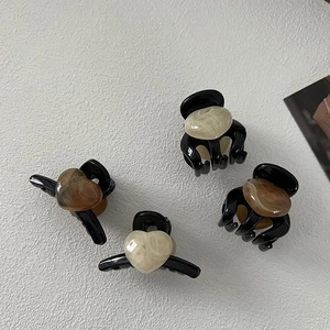 Set of 4 black heart hair claws with beige and amber resin accents on white background