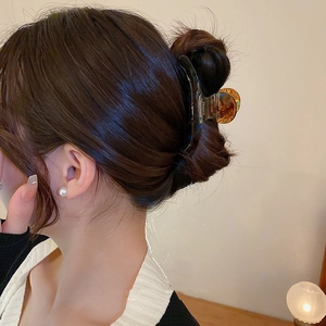 Detail of tortoise shell hair claw clip with gold France Handmade logo on hair bun