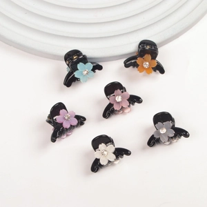 Set of 6 mini flower hair claws with rhinestone centers in various matte colors on white base