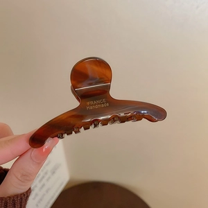 Detailed macro view of handmade amber tortoise shell hair claw with gold France lettering