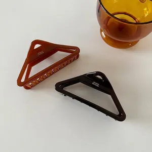 Large acetate hair claw clips in amber and black with hollow triangle design
