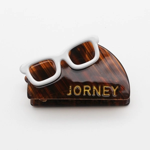Chic tortoiseshell acetate hair claw clip featuring a unique white eyewear design and logo