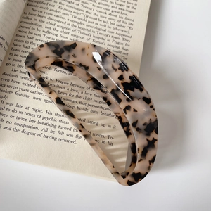 Elegant large tortoiseshell acetate hair claw clip with hollow rectangle design on book
