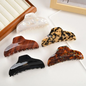 Macro detail of assorted acetate hair claws with premium Barrette La France gold engraving