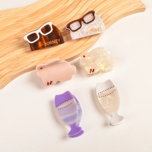 Détail de pinces à cheveux en acétate avec motifs lunettes, lapin et verre à vin