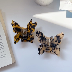 Detail view of double-layered butterfly hair claws in leopard and tortoiseshell patterns