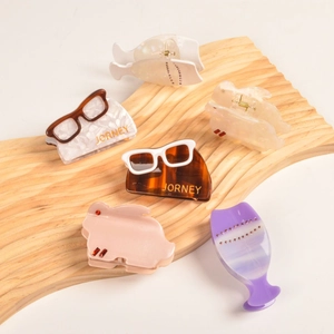 Vue détaillée des pinces à cheveux en acétate aux formes créatives de lunettes et animaux