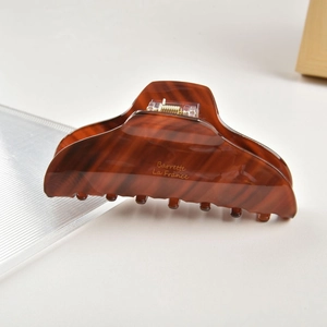 Detailed macro view of retro tortoiseshell hair claw clip with golden Barrette La France text