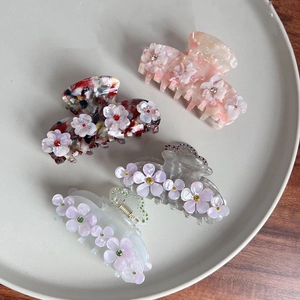 4er-Set elegante Blumen-Haarklammern aus Acetat mit Strasssteinen auf einem Tablett