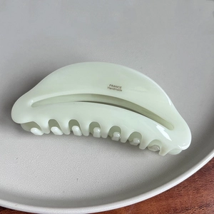 Detail of mint green acetate hair claw clip with golden France Handmade logo engraving