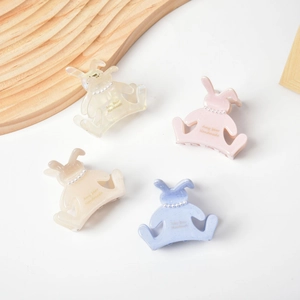 Vue détaillée de pinces à cheveux lapin en acétate avec perles et paillettes colorées