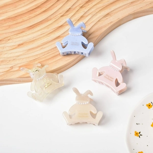 Gros plan de pinces à cheveux lapin en bleu clair, rose, beige et blanc perlé avec perles