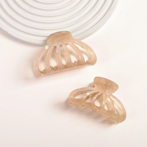 Detail view of pearlescent acetate hair claws in two sizes with shimmering texture