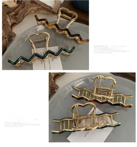 Detail view of wavy claw clips with tortoiseshell pattern and heart-shaped metal handles