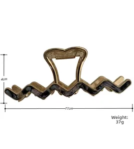 Detail view of wavy marble acetate shark hair clip with 11cm length measurement