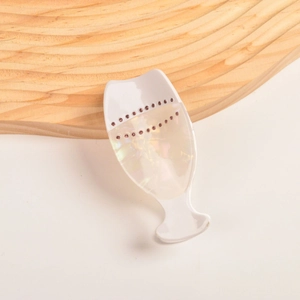 Détail d'une pince à cheveux en forme de verre à vin avec strass roses et nacre polie