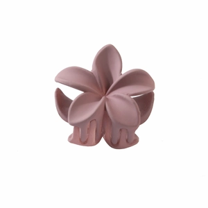 Close-up of matte dusty pink plumeria flower hair claw clip with interlocking teeth