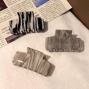 Three acetate rectangular hair claws in marble and zebra patterns for long hair styling