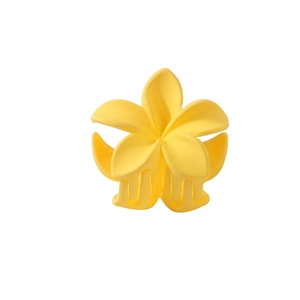 Detailed close-up of matte yellow frangipani flower hair claw clip with interlocking teeth