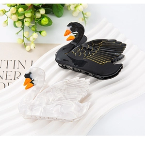 Elegant swan-shaped hair clips in black and white marble acetate with gold accents