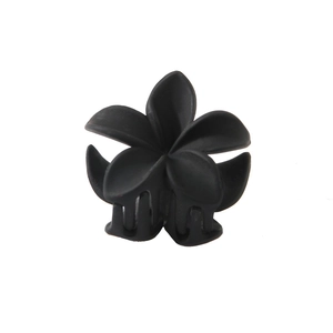 Macro detail of a black matte plumeria hair claw clip with its internal metal spring mechanism