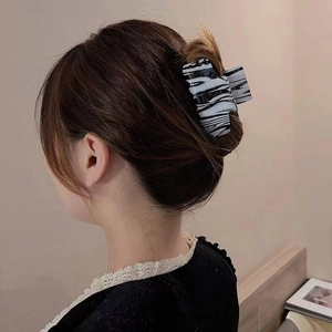 Women's large acetate hair claw clip with black and white zebra pattern on long hair