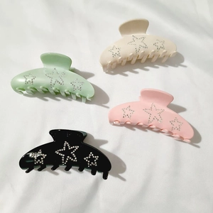 Set of four star-patterned acetate hair claws in white, green, pink, and black