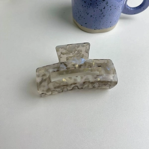 Detail view of square marble acetate hair claw clip with pearlescent finish