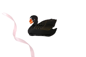 Detail of elegant black swan hair claw clip with gold wing lines and orange beak accent