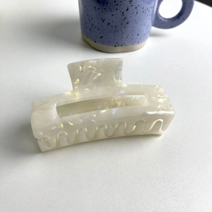 Detail of square hollow hair claw with pearlescent finish and iris texture