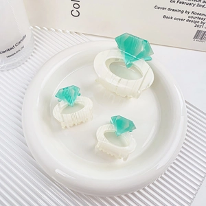 Three-piece set of cream and green diamond hair claws in a minimalist ceramic dish